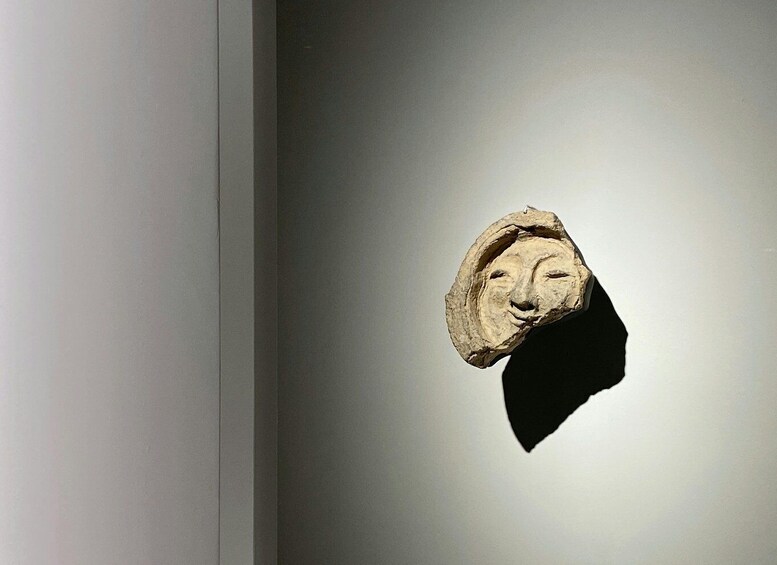 A sculpture of a human head on a wall. 1