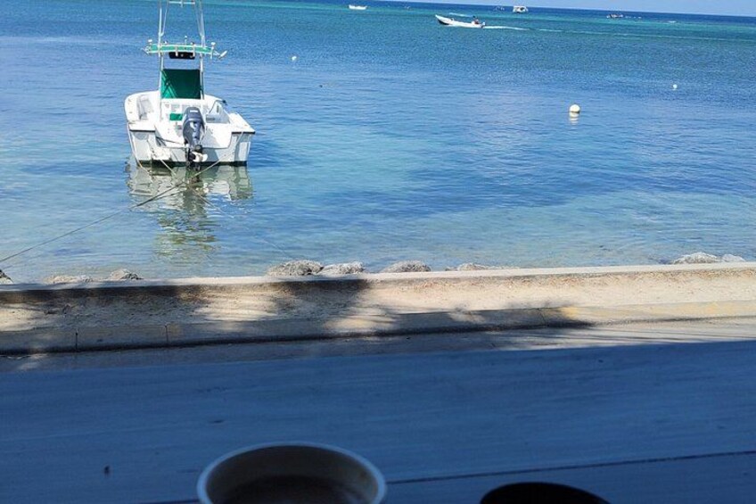 Un barco atracado cerca de una playa arenosa, con aguas tranquilas y un cielo despejado. 4