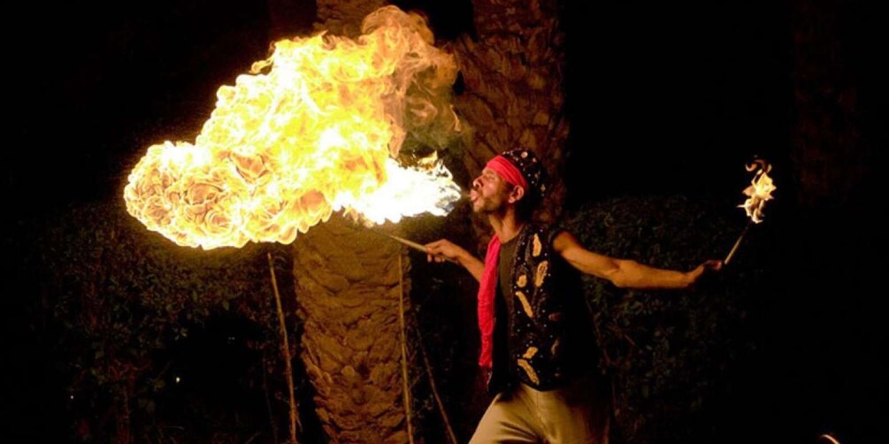 A person performing fire tricks with a flaming staff. 1