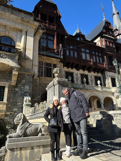 A historic building with ornate architecture, a stone lion statue, and a clear blue sky. 2
