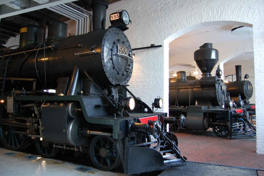 A steam locomotive with the number 555, displayed in a museum setting. 1