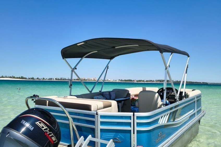 A blue and white motorboat with a canopy, a Yamaha outboard motor, and clear turquoise water. 4