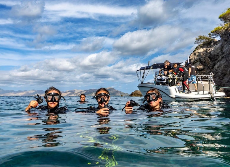 A group of people scuba diving near a boat on a clear day. 5