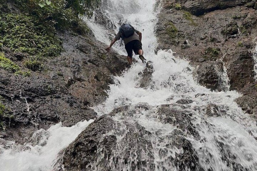 A person navigating a rocky waterfall. 1
