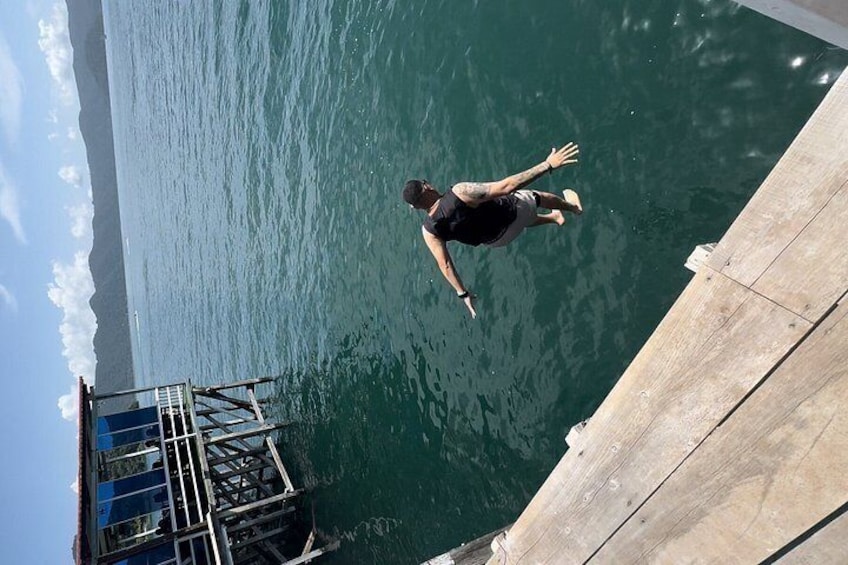 A person jumping off a dock into water. 2