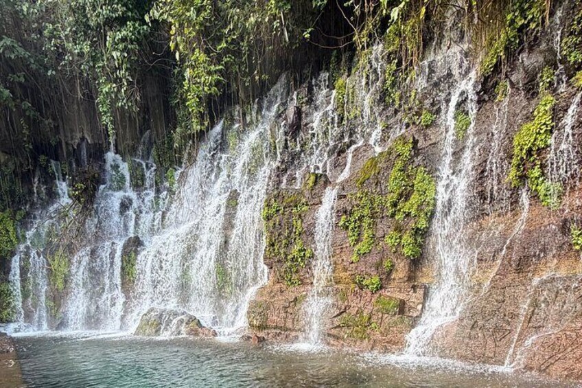 A waterfall cascading over a rocky cliff into a pool below. 3