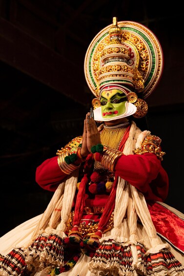 A performer in traditional costume with elaborate headgear and jewelry. 1