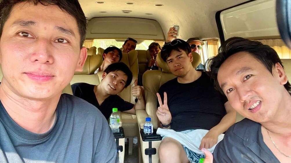 A group of people inside a vehicle with a water bottle on the seat. 1