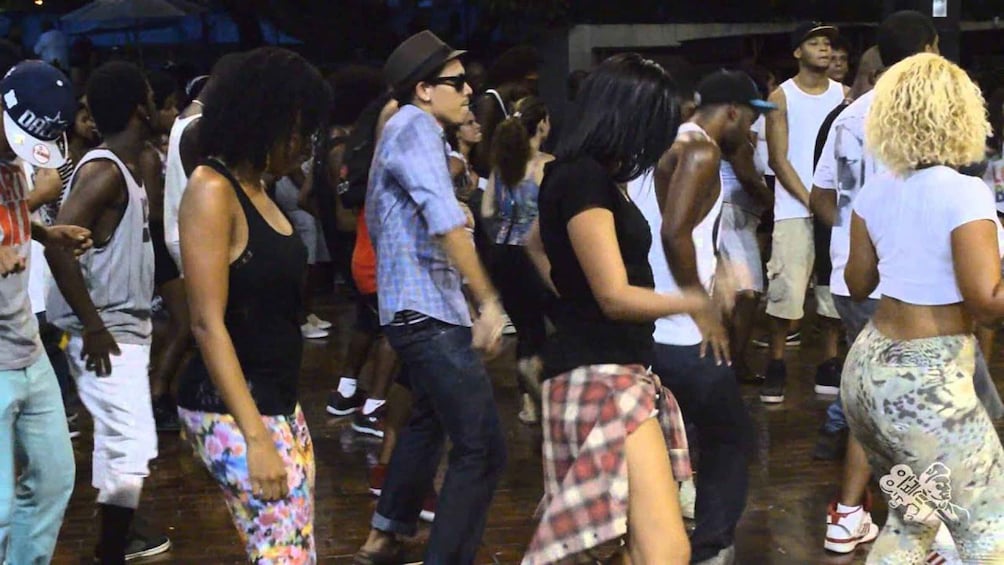 A crowded indoor event with people dancing and socializing. 3