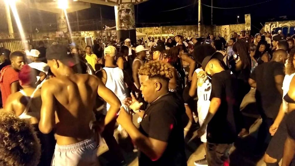 A crowded outdoor event with people standing and interacting. 2
