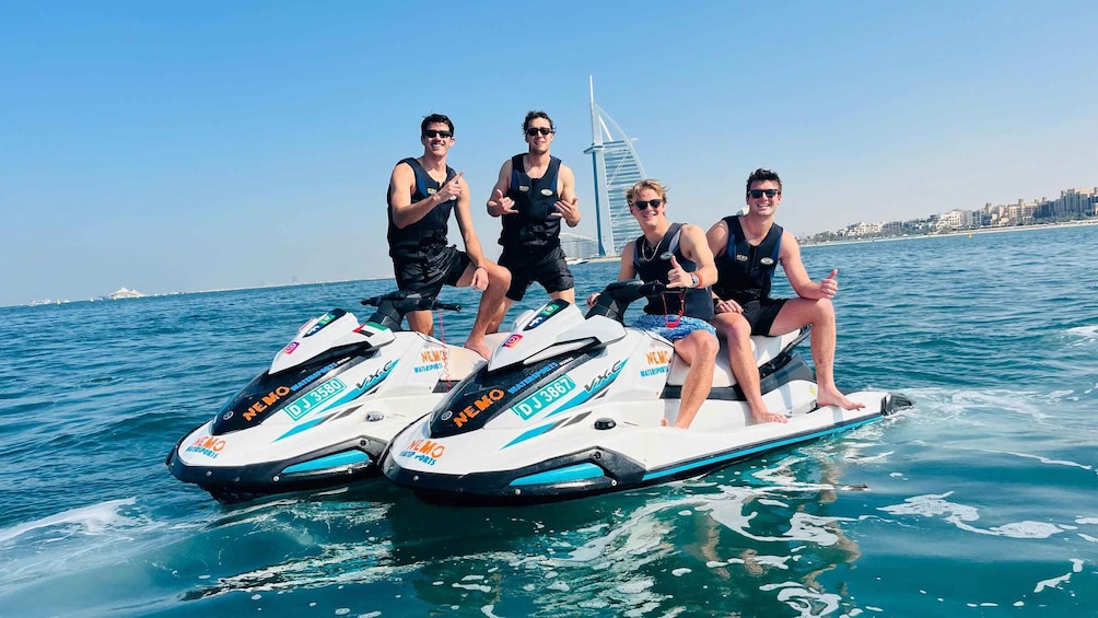 Four people on jet skis with a sailbridge in the background. 3