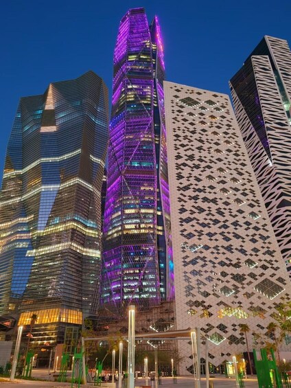 Un paisaje urbano con rascacielos modernos, uno de ellos con iluminación púrpura. 4