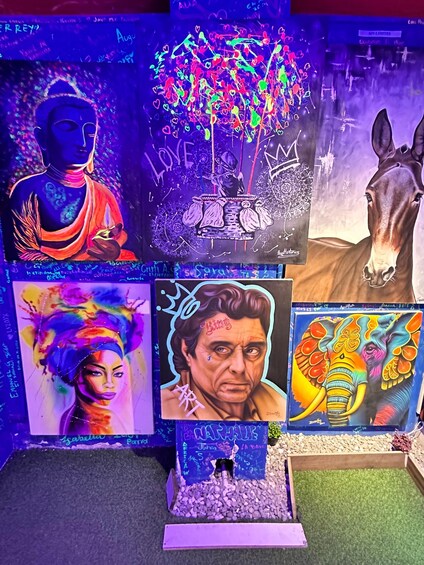 A collection of vibrant artworks including a Buddha, a tree with hearts, a horse, a woman with a colorful headpiece, a man with a crown, and an elephant. 5
