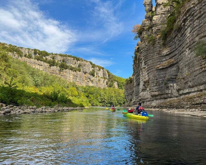 Kayakers on a river surrounded by cliffs. 1