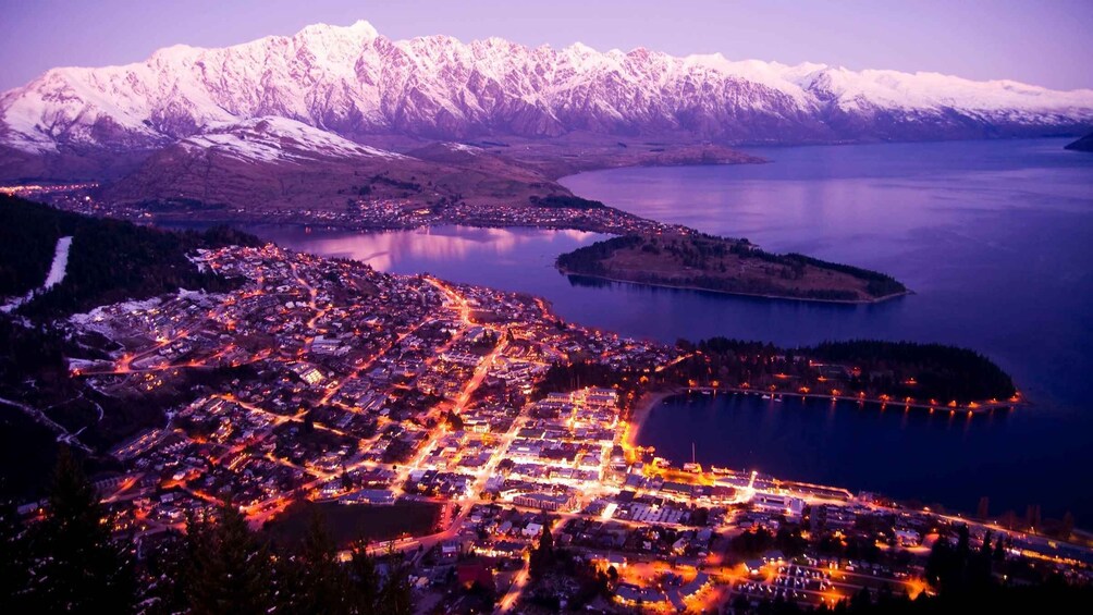 A town by a lake with snow-capped mountains in the background. 3