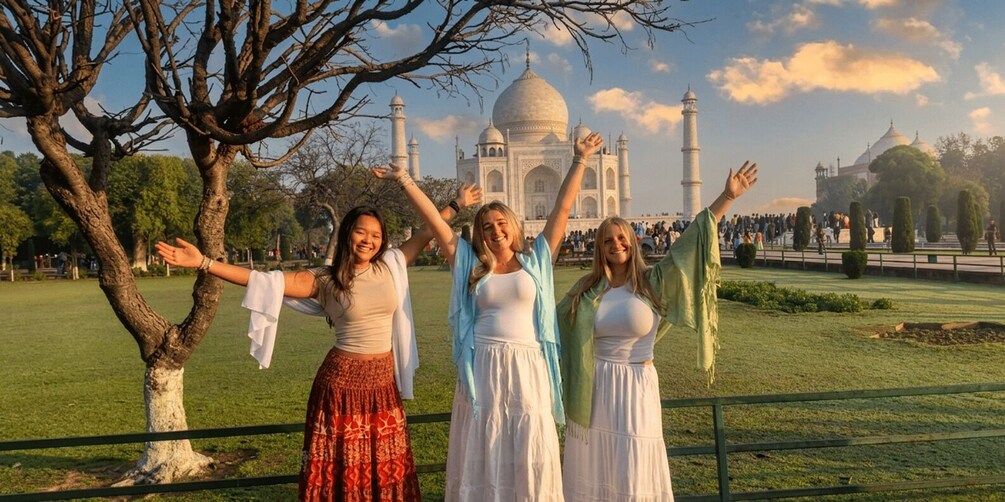 Trois personnes se tiennent devant le Taj Mahal, les bras levés. 5
