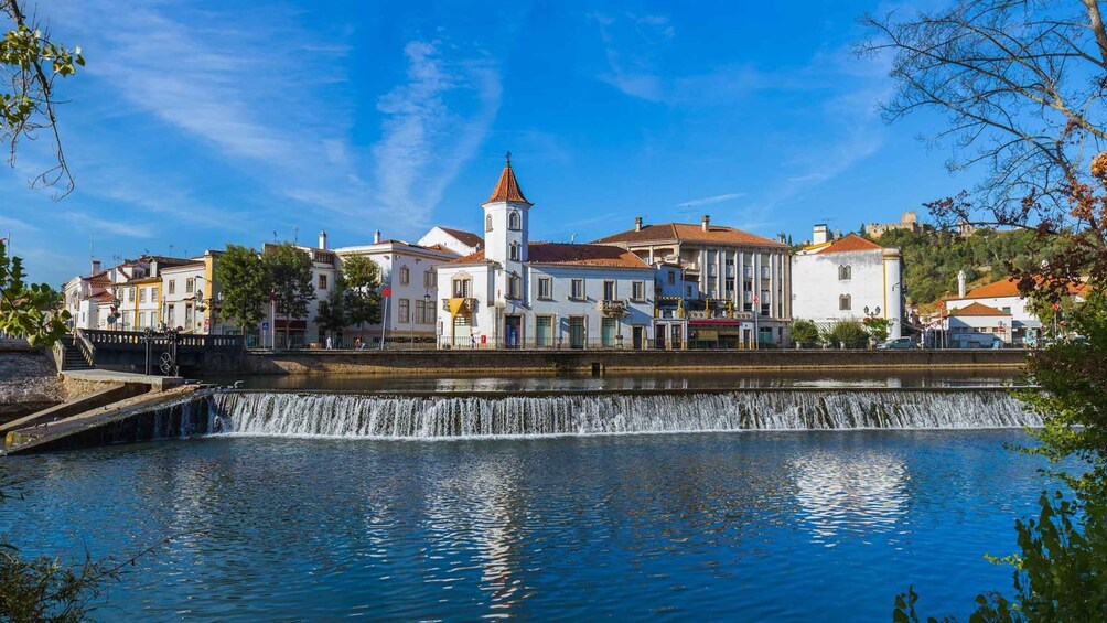 A town with a central square, a church with a bell tower, and a flowing water feature. 2
