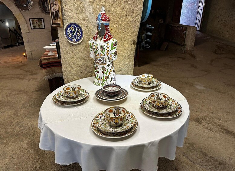 A table set with ornate plates and a pitcher, surrounded by decorative plates on the wall. 5