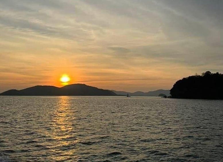A sunset over a calm body of water with distant landforms. 5