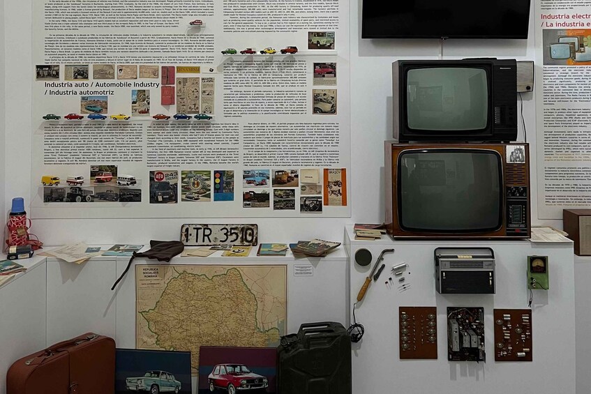 A display of automotive history with vintage cars, a map, and electronic components. 5