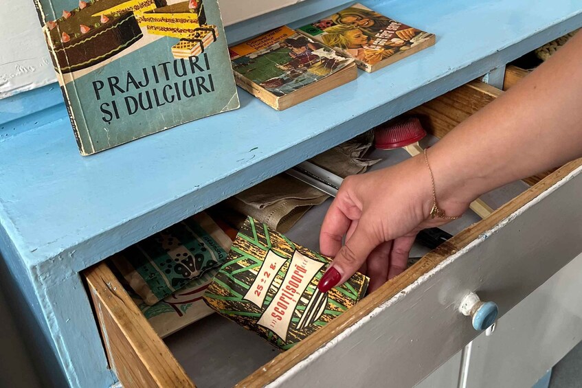 A hand reaching into a drawer with a box labeled "PRAJITURI SI DULGIRI". 2