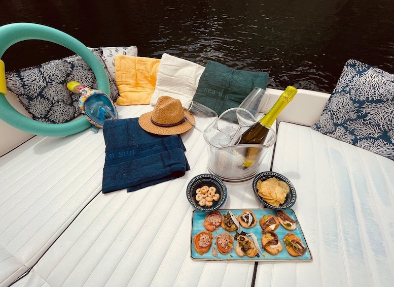 A boat with a bottle of champagne, snacks, and a straw hat on the deck. 5