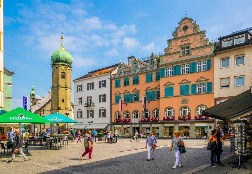 A bustling square with historic buildings, a prominent tower, and outdoor cafes. 5