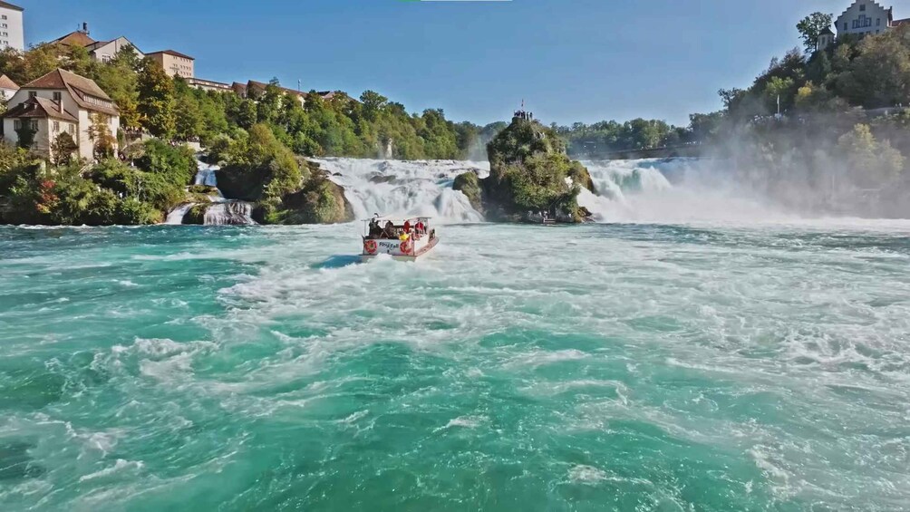 A boat navigating a river with a waterfall in the background. 3