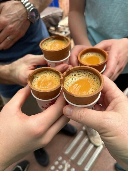 Four small cups of coffee held by hands. 2
