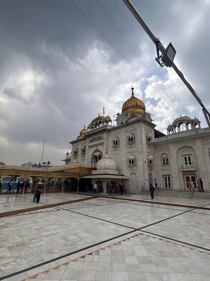 A large, ornate building with multiple domes and a central golden dome, surrounded by a tiled courtyard. 1
