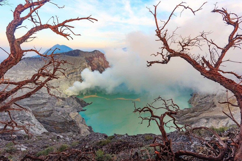 A mountainous landscape with a turquoise lake surrounded by rocky terrain and bare trees. 4