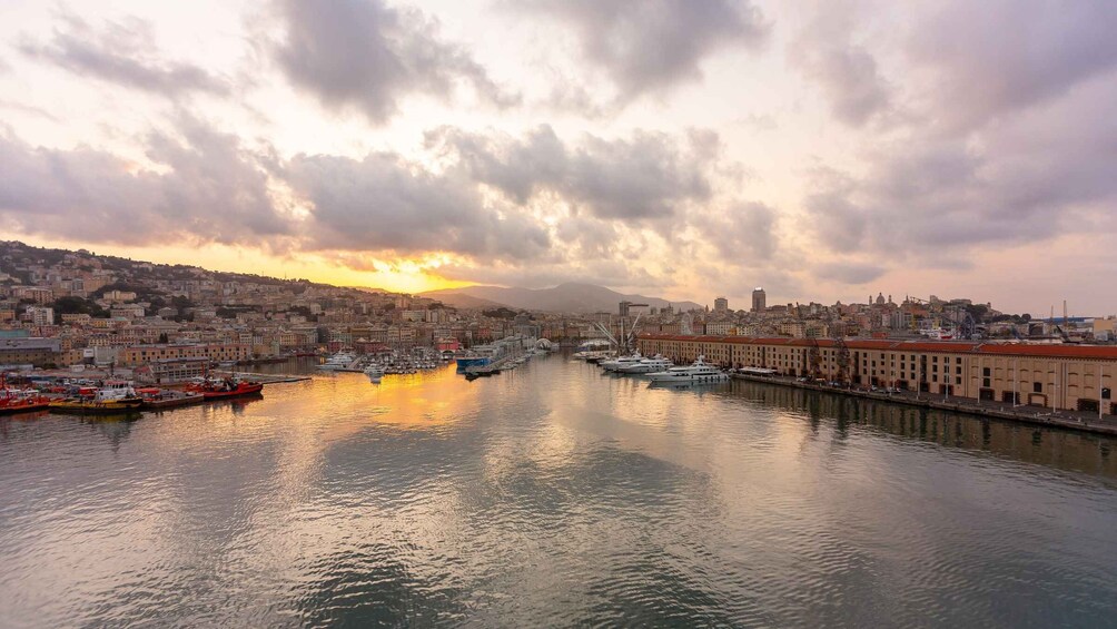 A harbor with boats and a cityscape during sunset. 5