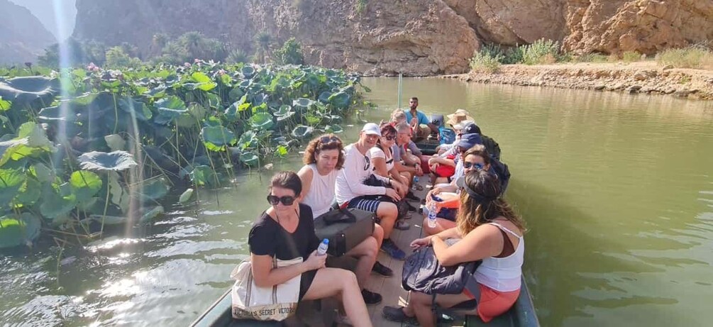 A group of people on a boat surrounded by water lilies. 4