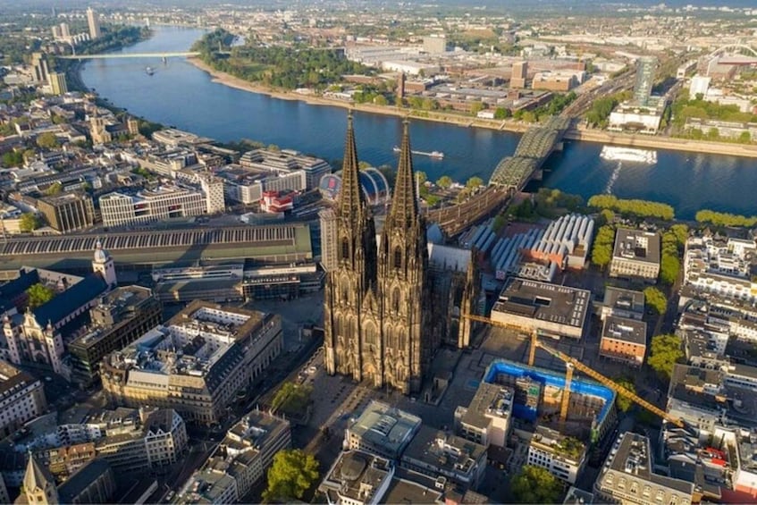 An aerial view of a city with a prominent cathedral, a river, and surrounding buildings. 2