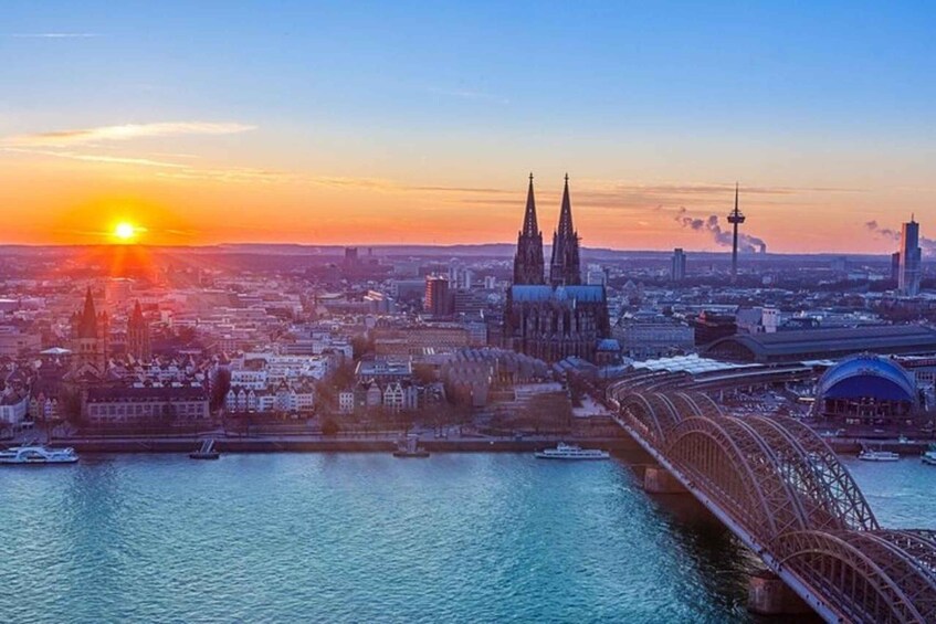 A cityscape at sunset with a prominent cathedral, a bridge, and a tower. 5