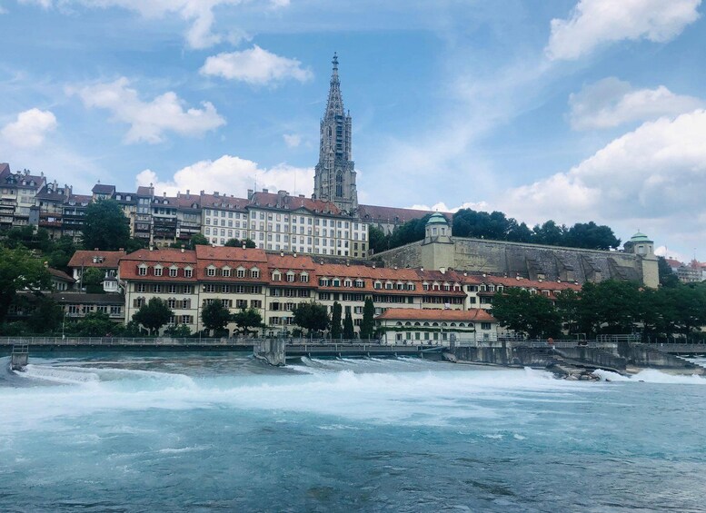 A river with waves, a castle, and a tall church tower. 1
