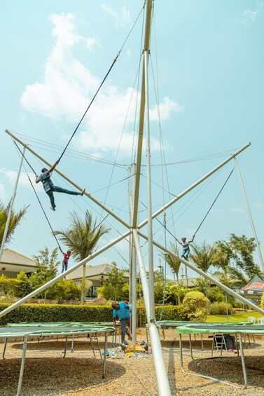 A trapeze park with multiple trapeze setups and people performing. 4
