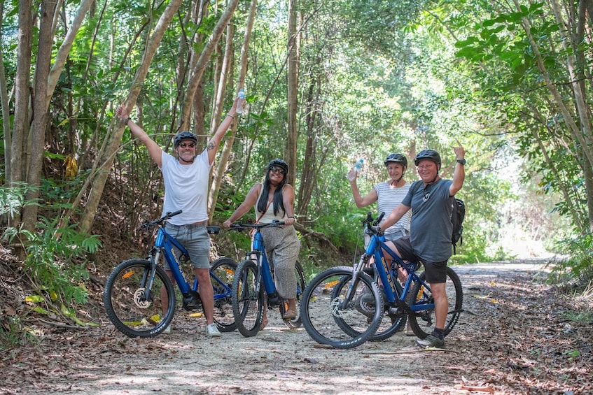 Four people on bicycles in a forested area. 4