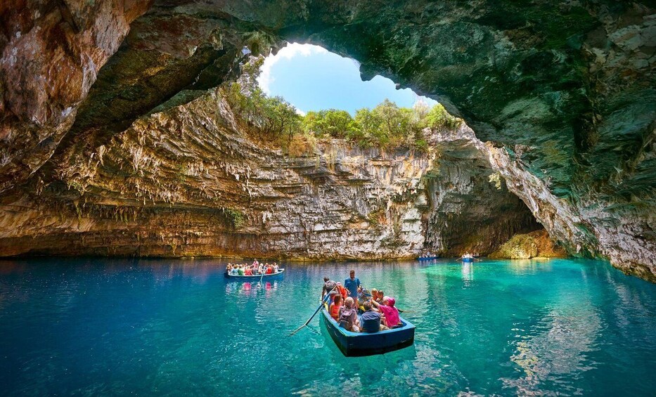 A boat tour through a cave with clear turquoise water and a natural arch formation. 5