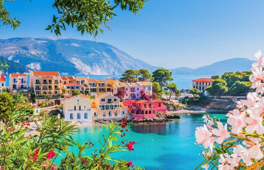 A coastal village with colorful buildings, a clear blue sea, and mountains in the background. 3