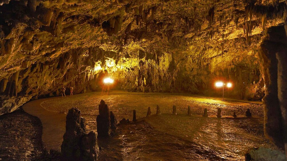 A cave with stalactites and stalagmites, illuminated by lights. 2