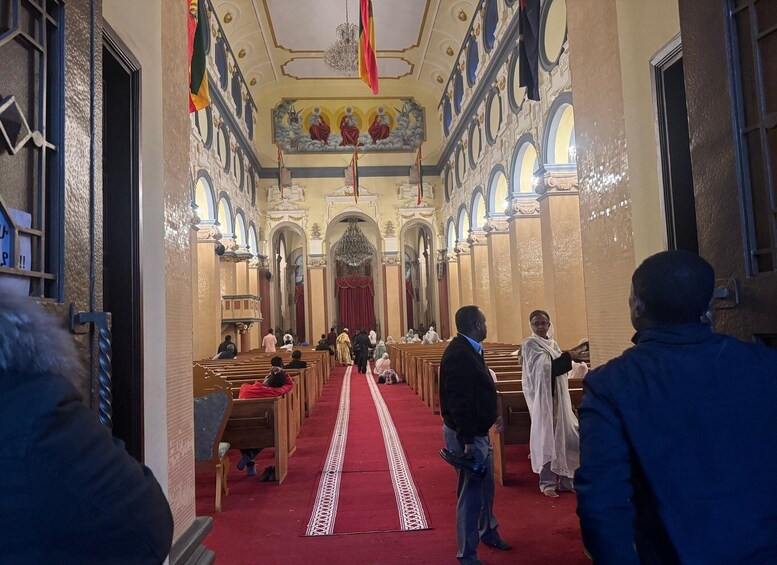 A church interior with rows of pews, a red carpet, and a chandelier. 5