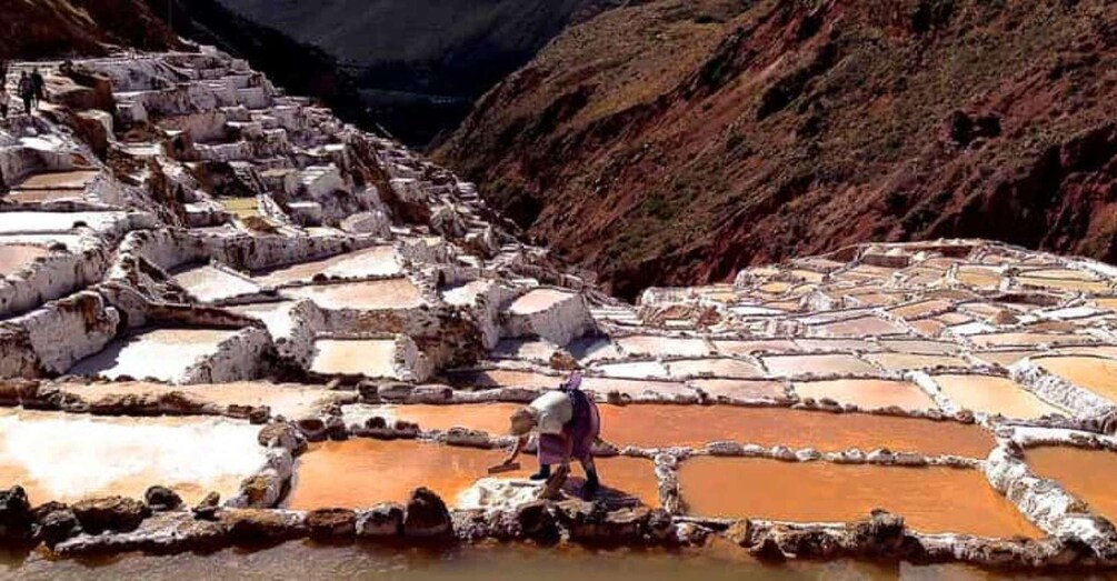 Terraced salt pans with a person working in the foreground. 3