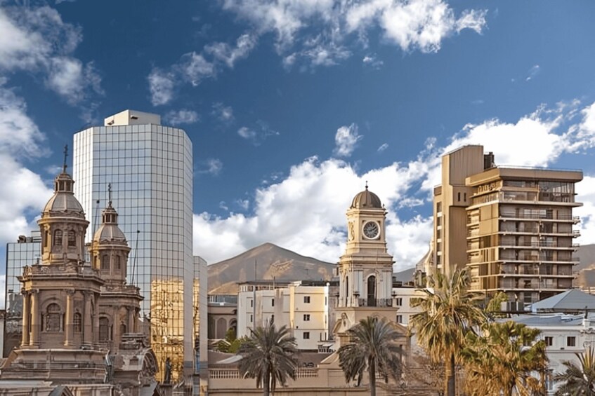 A cityscape with a modern glass building, a historic clock tower, and palm trees. 2