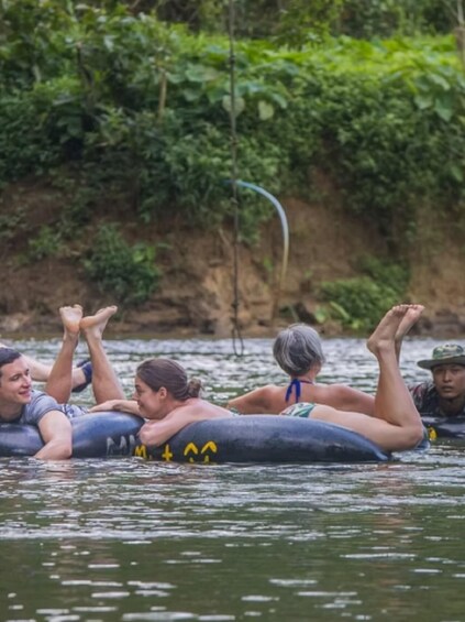 People floating on a raft in a river surrounded by greenery. 4