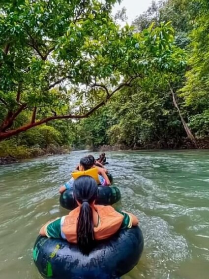 People rafting down a river surrounded by dense green foliage. 5