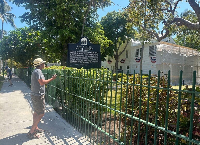 A man reading a sign about The Little White House. 5