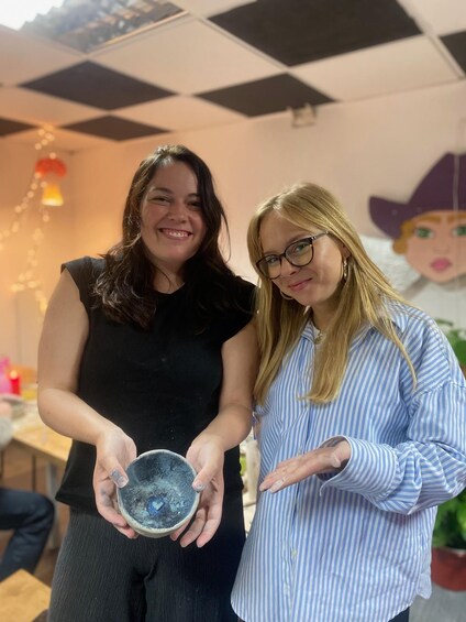 Two people holding a bowl. 4