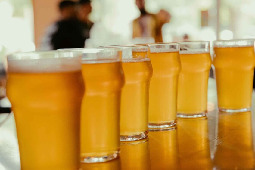 A row of amber-colored beer glasses on a table. 5