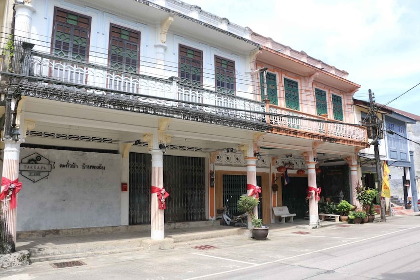 A traditional building with a balcony, columns, and potted plants. 4